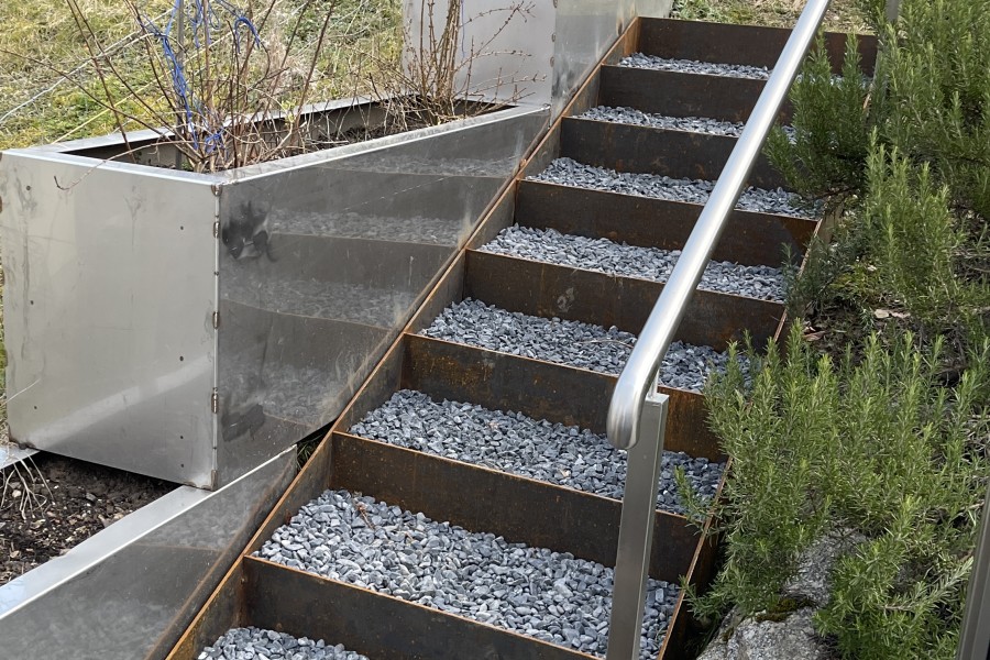 Cortenstahl Treppe auf Kundenmass mit Pflanzentrge aus Edelstahl & separatem Treppen-Handlauf. 
Treppe gefllt mit Zierkies. 